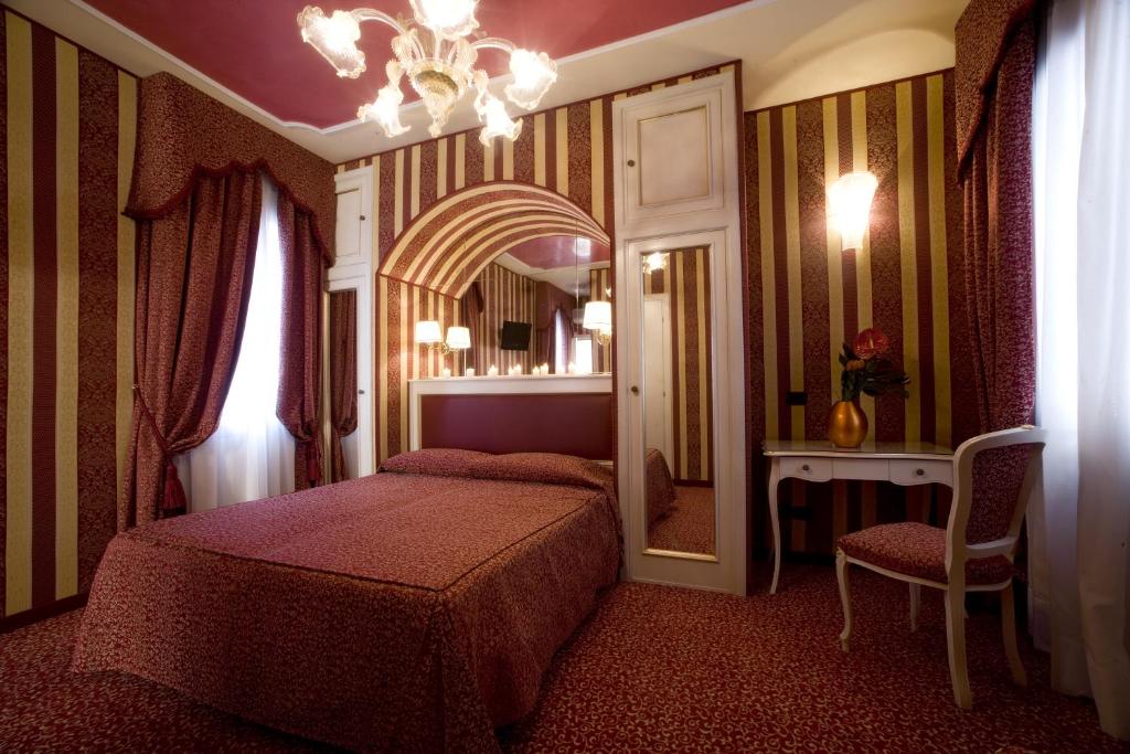 a bedroom with two beds and a mirror at Hotel Alcyone in Venice