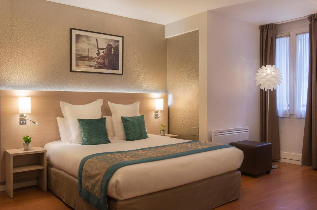 パリにあるクラシック ホテル バスティーユの大きなベッド(緑の枕付)が備わる客室です。