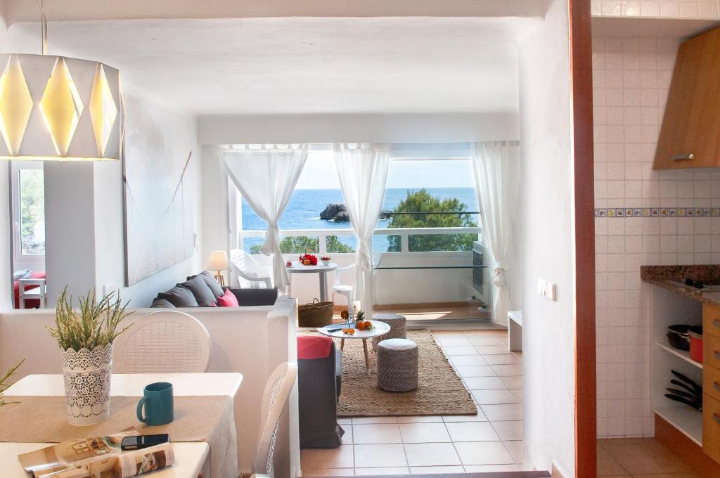 uma cozinha e sala de estar com vista para o oceano em Apartamento Ferrera Park 505 em Cala Ferrera