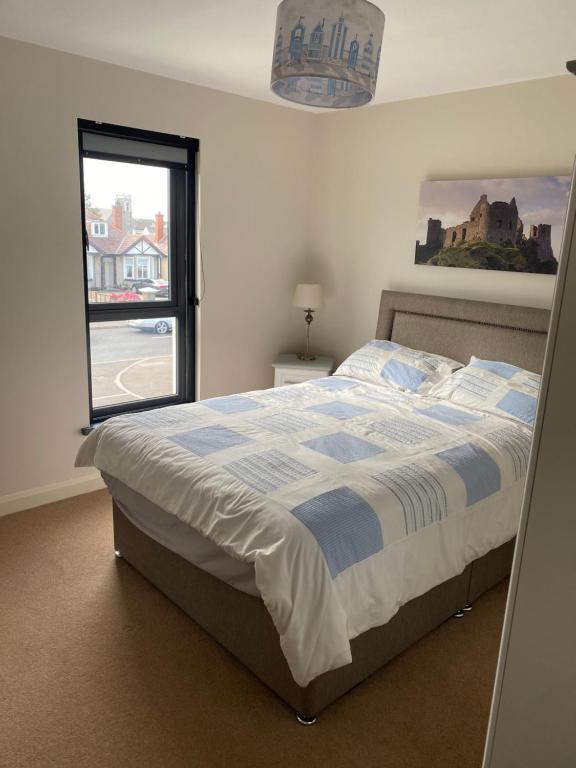 a bedroom with a large bed with a window at Westerlies in Portrush