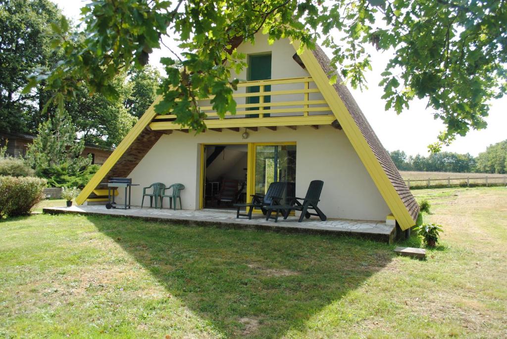 ein kleines Haus mit gelbem Dach in der Unterkunft Domaine De La Tuillerie in Chaillac