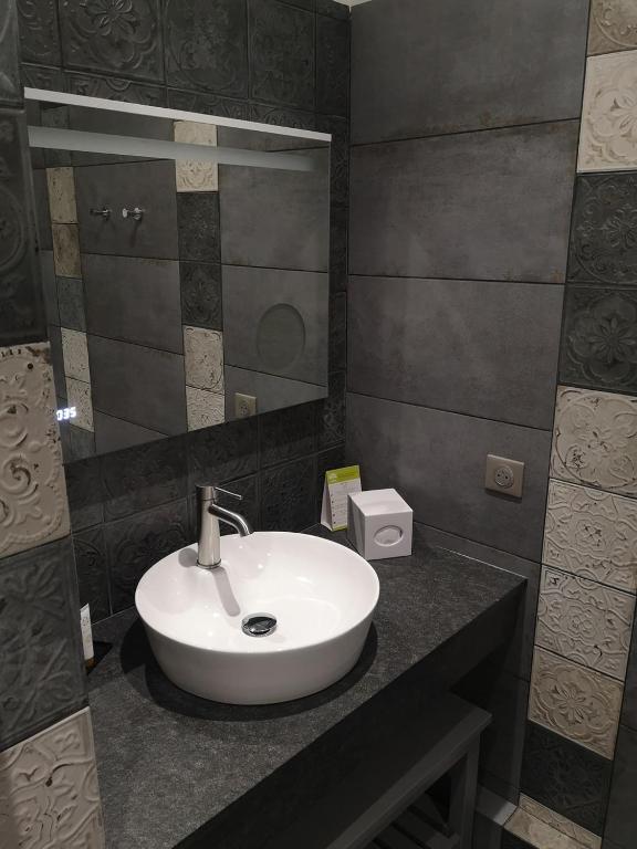 a bathroom with a white sink and a mirror at Villa Augeval Hôtel de charme & Spa in Deauville