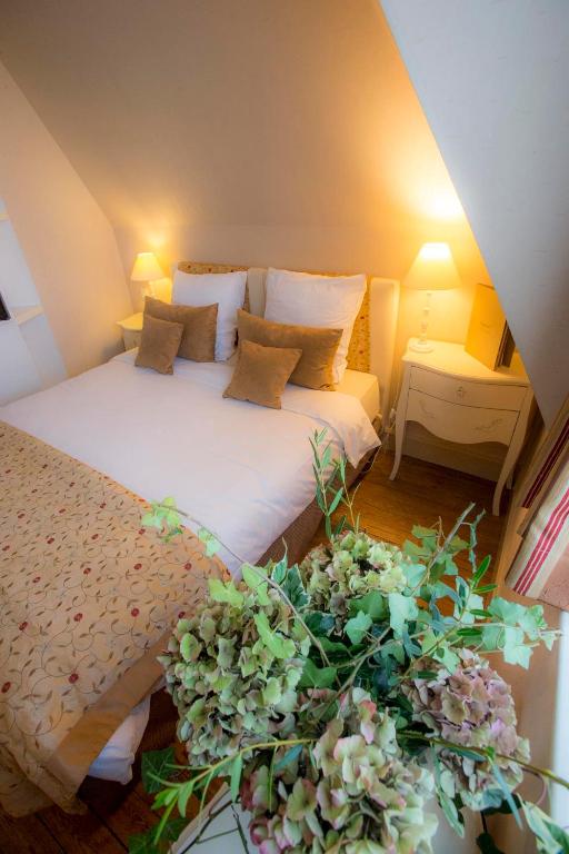 a bedroom with a bed and a plant on the floor at Villa Augeval Hôtel de charme & Spa in Deauville