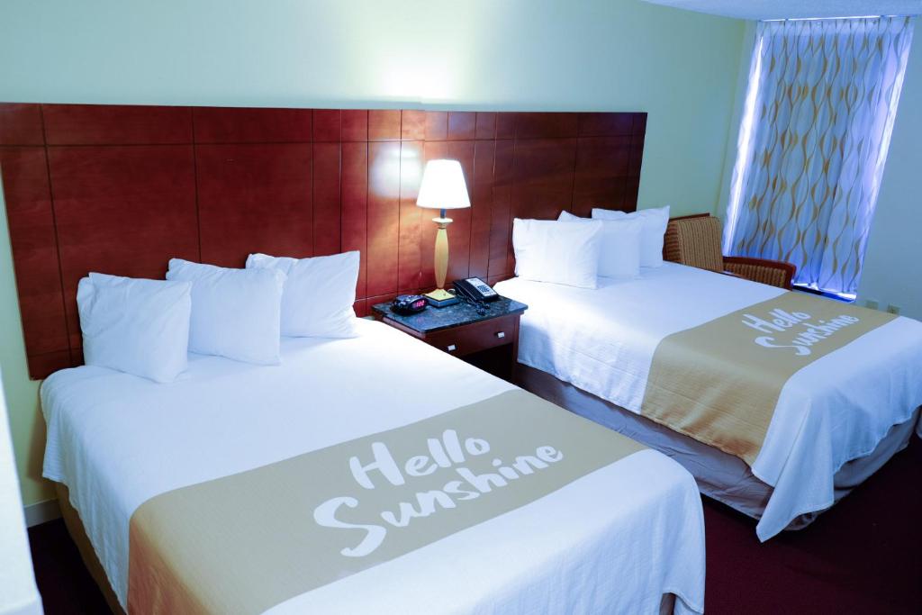 a hotel room with two beds with white sheets at Rodeway Inn High Point - Archdale in Archdale