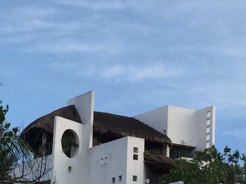 a white building with a hill in the background at Mi Casa en Cozumel in Cozumel