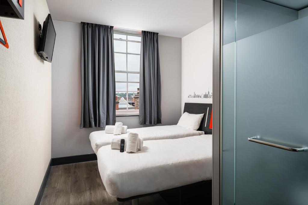 a hotel room with two beds and a window at easyHotel Ipswich in Ipswich