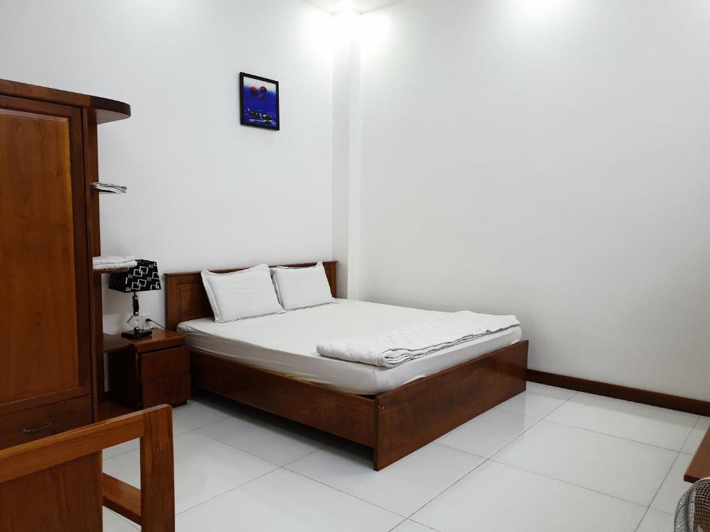 um pequeno quarto com uma cama com lençóis brancos em hotel đăng khôi 2 em Chau Doc