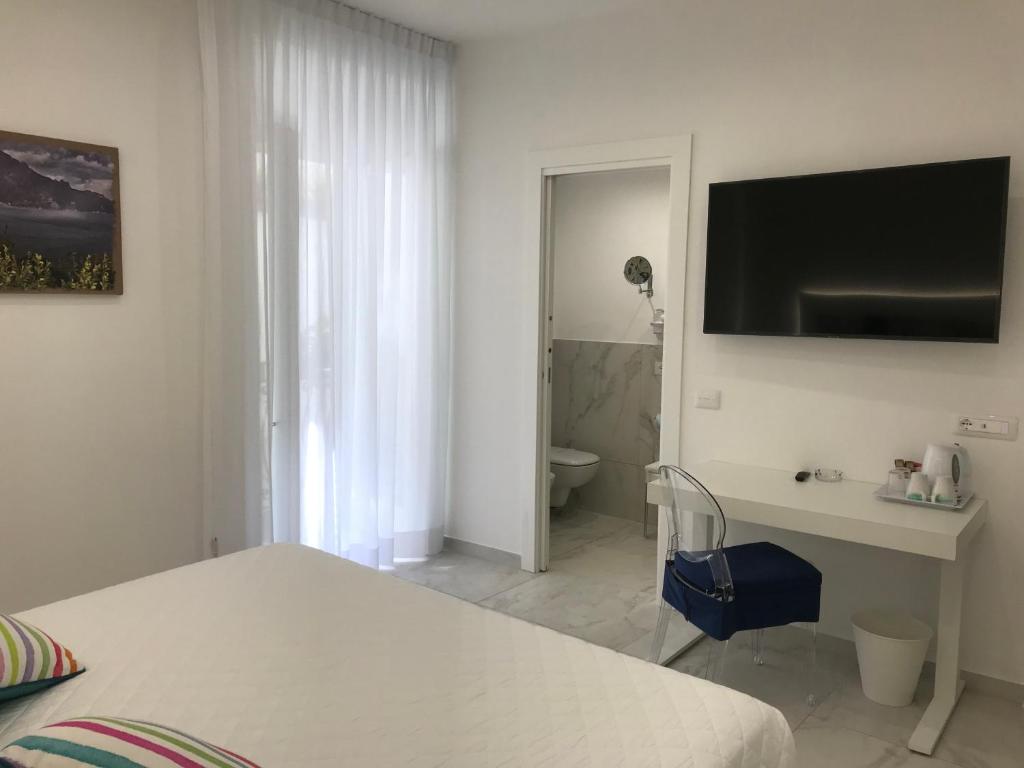 a bedroom with a bed and a desk and a bathroom at Amalfi Suite Boutique Hotel in Amalfi