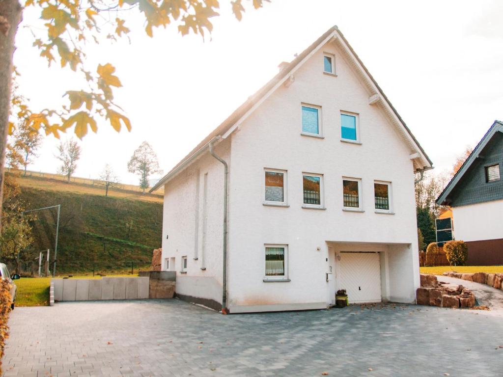 ein weißes Haus mit Auffahrt in der Unterkunft Ferienhaus Paula in Olsberg