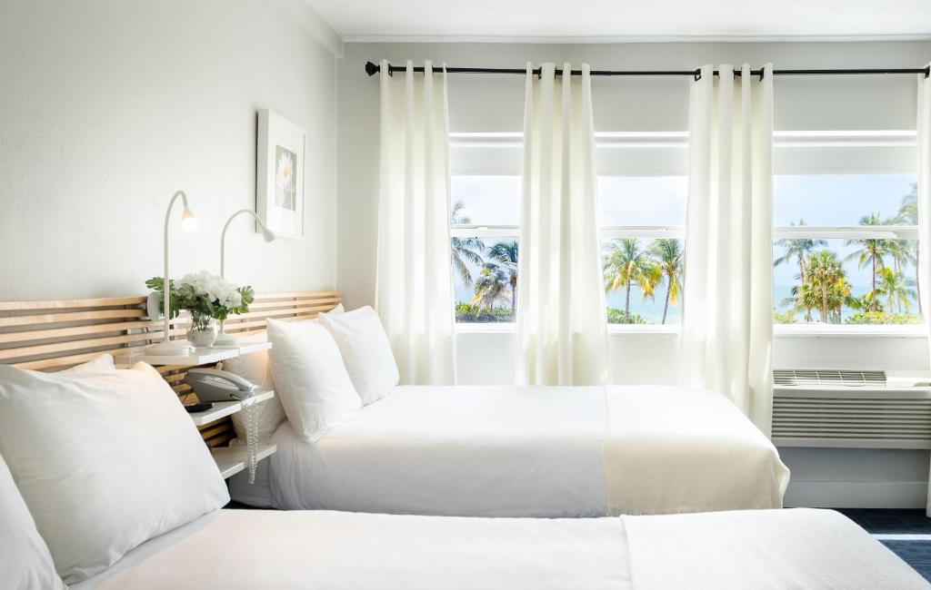 a hotel room with two beds and a window at Lorraine Hotel in Miami Beach
