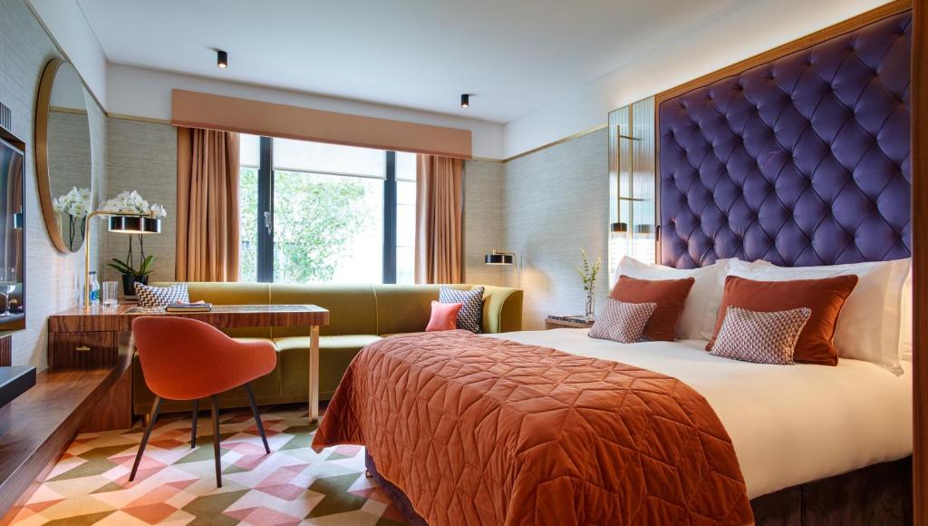 a bedroom with a large bed and a large window at The Fitzwilliam Hotel in Dublin