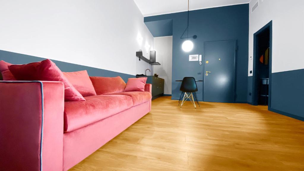 un sofá rosa en una sala de estar con paredes azules en BNB Capital Milano Central Station - Red, en Milán