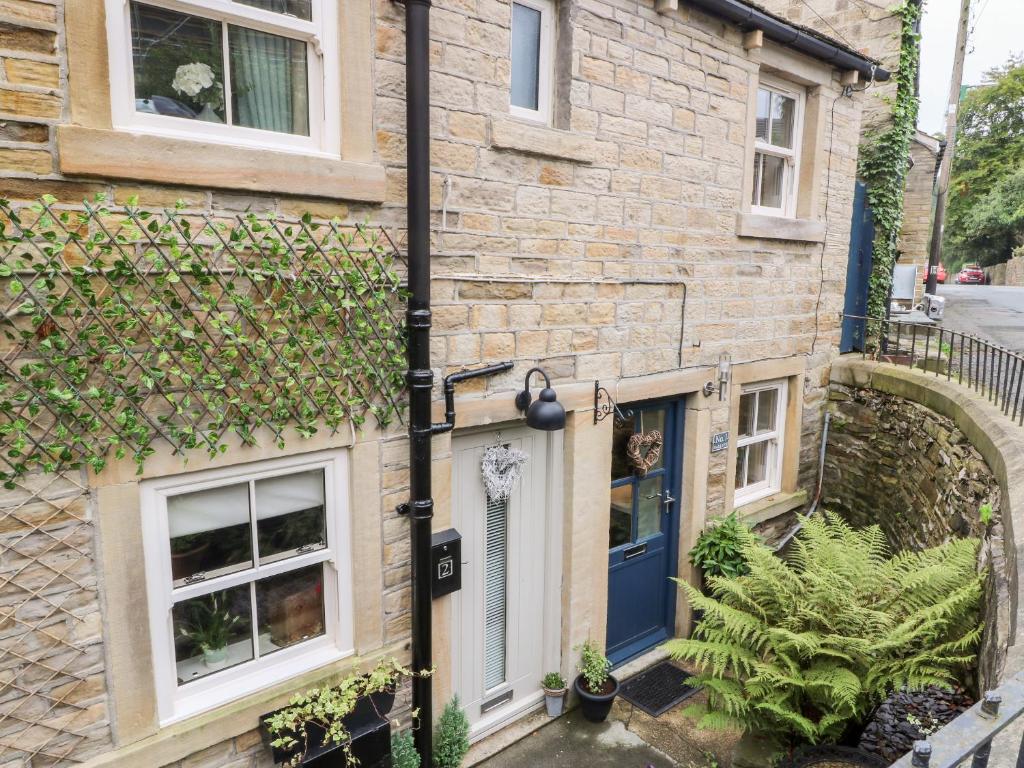 a brick house with a blue door at 1 Oakleys in Holmfirth