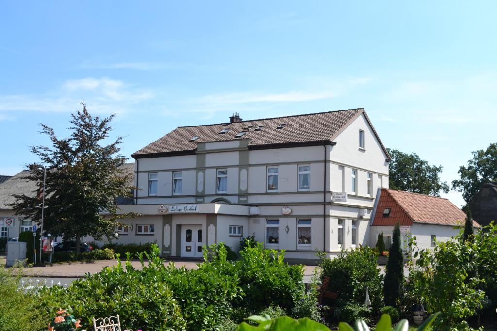 um grande edifício branco com telhado em Ladiges Gasthof em Holm