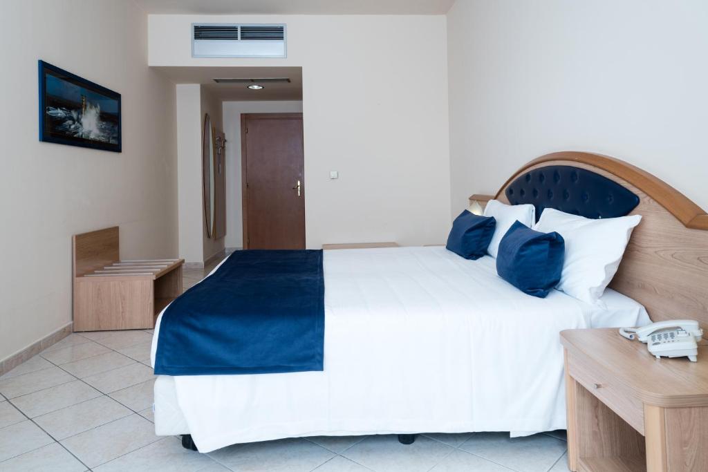 1 dormitorio con 1 cama blanca grande con almohadas azules en Blu Hotel - Sure Hotel Collection by Best Western, en Collegno