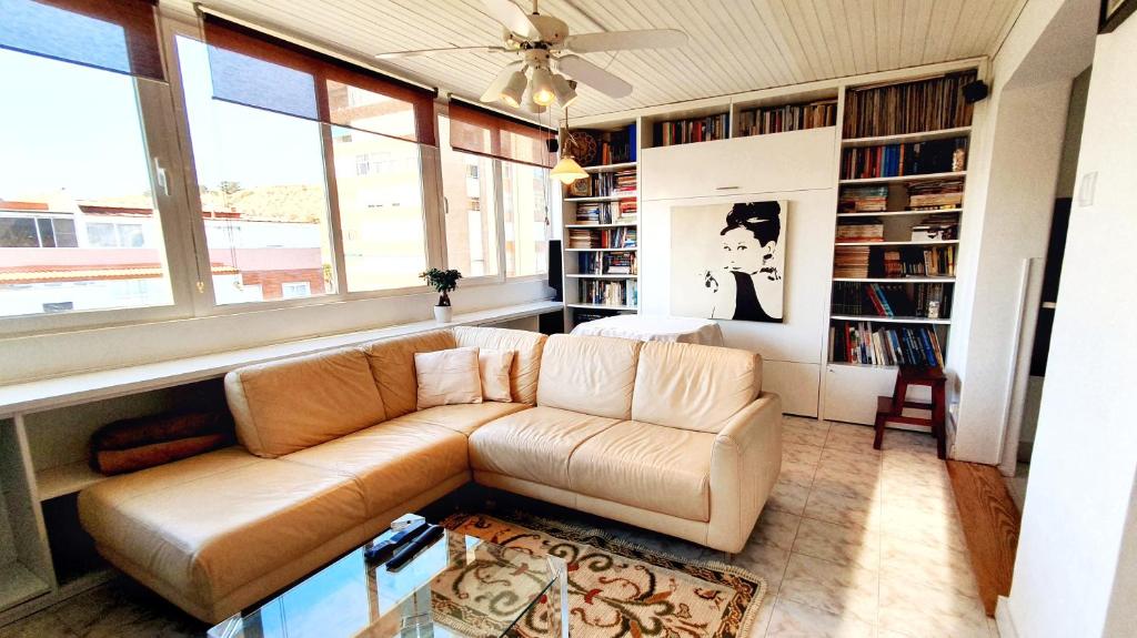 una sala de estar con un sofá de cuero marrón y estanterías en New! Nice FAMILY Apartment with 2 Bedroom, 2 Terrace en Costa da Caparica