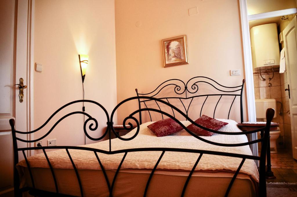 a bedroom with a bed with a wrought iron headboard at Apartments Villa Devana in Opatija