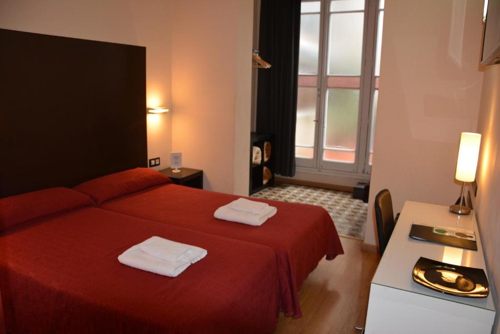 a hotel room with a red bed and a window at Center Gran Via in Barcelona