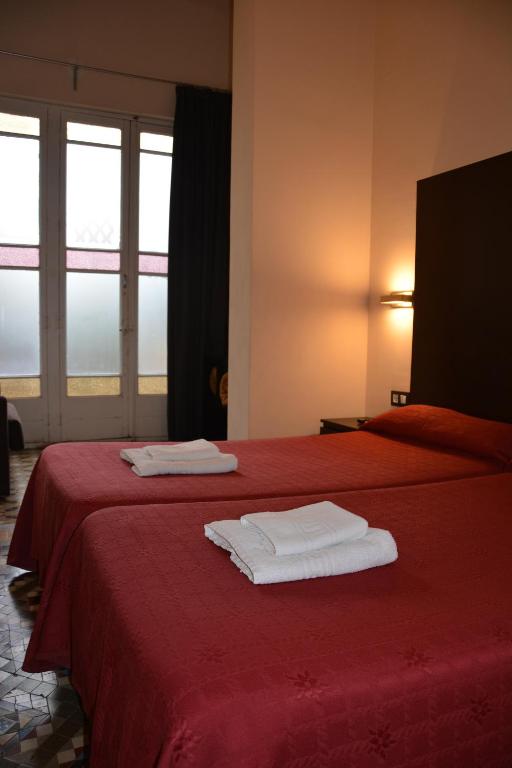 a red bed with two towels on top of it at Center Gran Via in Barcelona