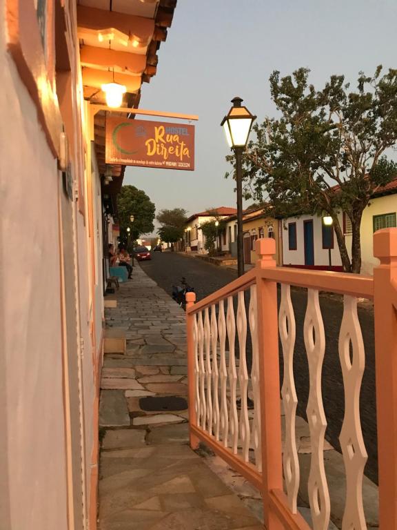 una calle con una valla y un cartel en un edificio en Hostel Rua Direita Pirenópolis, en Pirenópolis