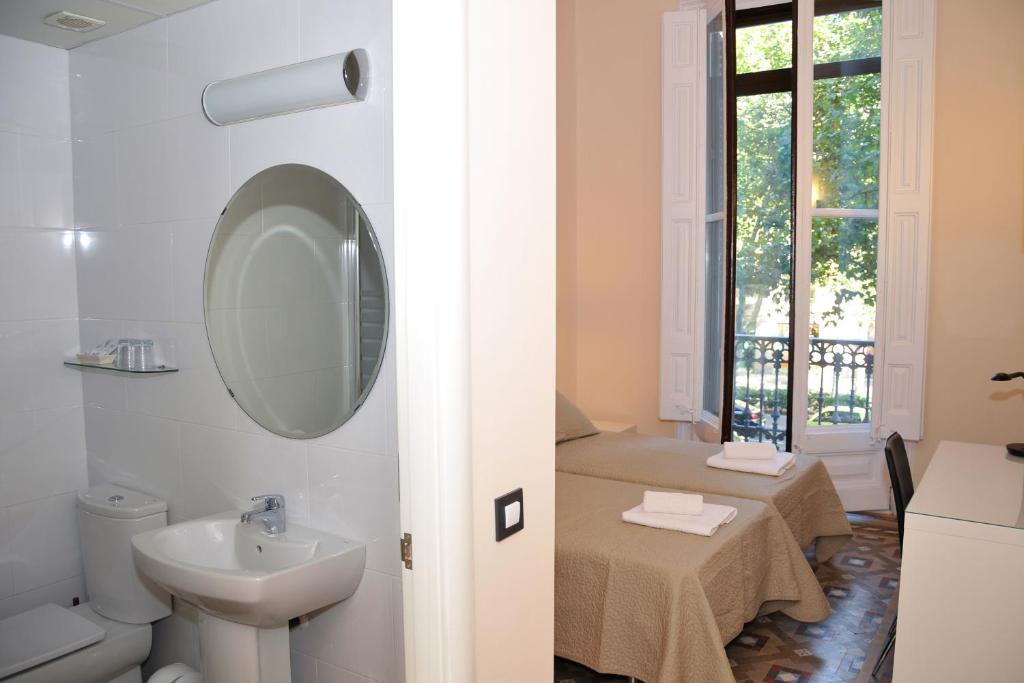 a bathroom with a sink, toilet and a window at Center Gran Via in Barcelona