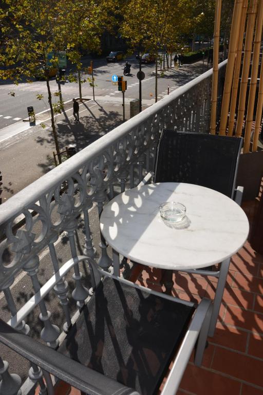 - Balcón con mesa blanca y sillas en Center Gran Via, en Barcelona