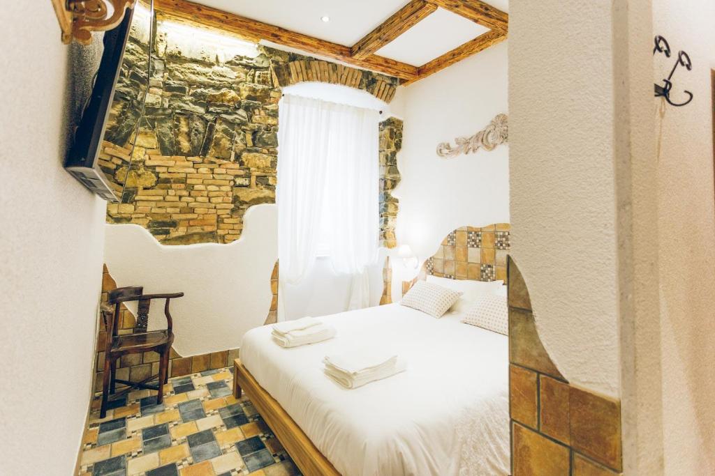 a bedroom with a bed and a brick wall at AQUILA D'ORO TRIESTE in Trieste