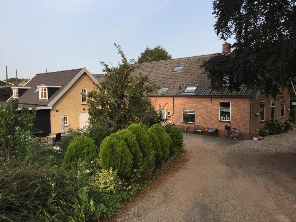 a house with a driveway in front of it at Het Boenhok logies in Lekkerkerk