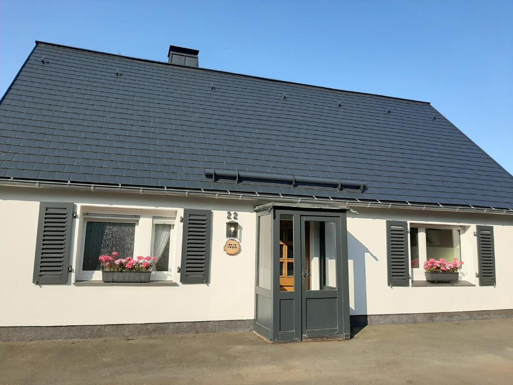 a white house with a black roof and two windows at Villa SKYLO in Winterberg