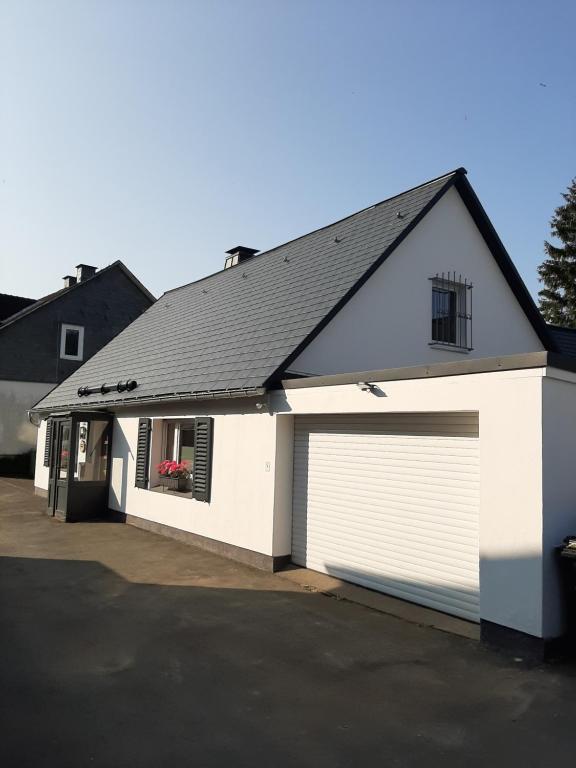 a white garage with a black roof at Villa SKYLO in Winterberg
