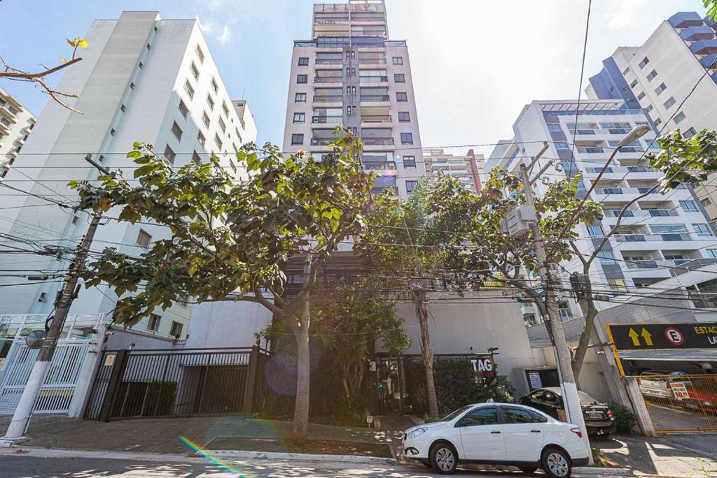 a white car parked in a city with tall buildings at Tag Decor in Sao Paulo