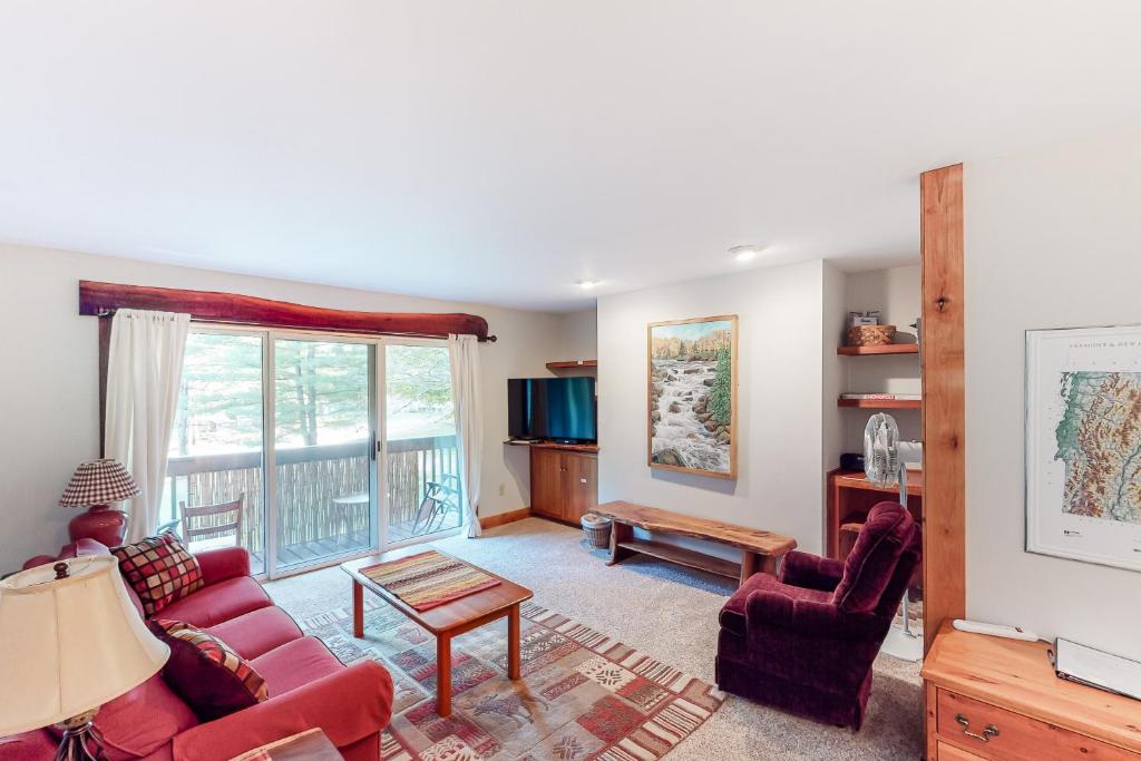 een woonkamer met rode meubels en een groot raam bij Mountain Breeze Getaway Condos in Warren