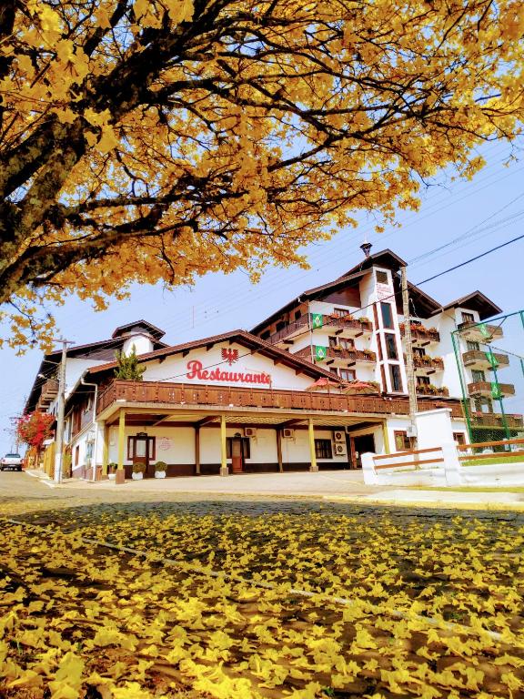 a building with autumn leaves in front of it at Hotel Tirol in Treze Tílias