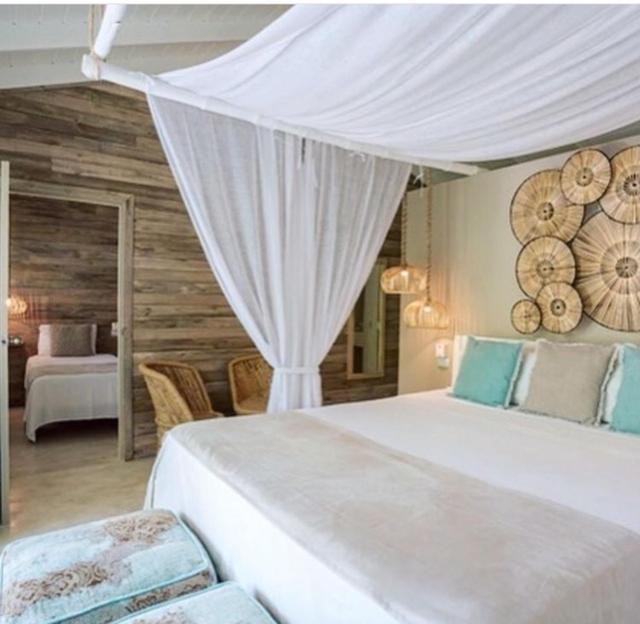 a bedroom with a large white bed with a canopy at Mahona Boutique Hotel in Las Terrenas