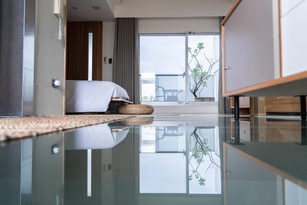 Habitación con cama y reflejo en el suelo en 台南安平Viva漁樂活民宿 en Anping