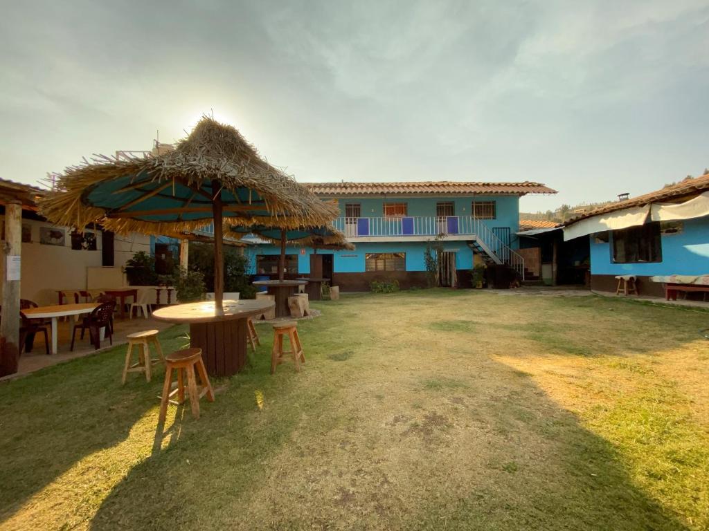 un patio con sombrilla, mesas y sillas en La Olla Peruana, en Cusco