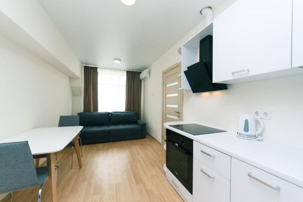 a kitchen and living room with a couch and a table at Smart House 11 in Kyiv