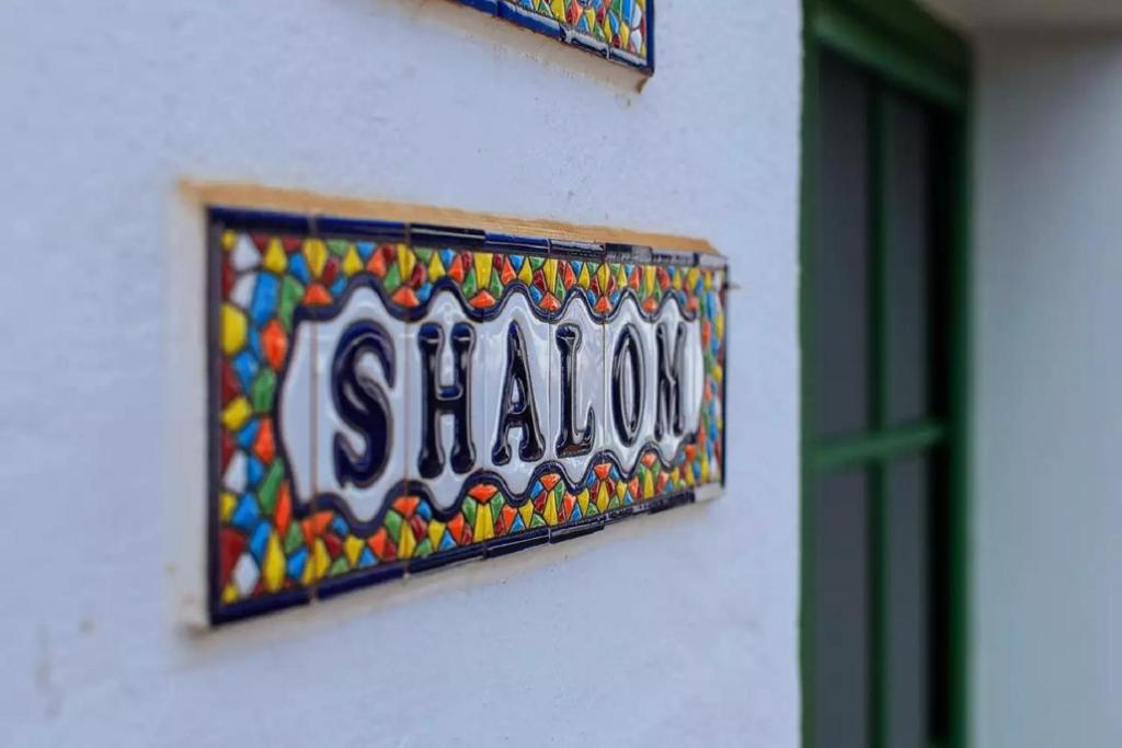 a sign on the side of a building at Shalom in Playa Blanca
