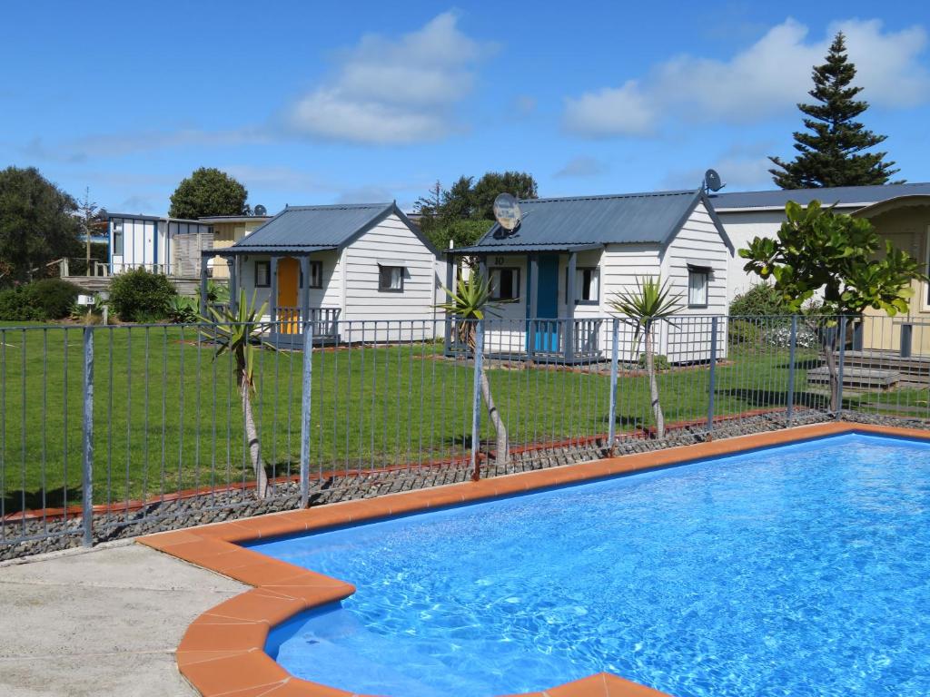 a swimming pool in front of a house at Whanganui Seaside Holiday Park in Whanganui