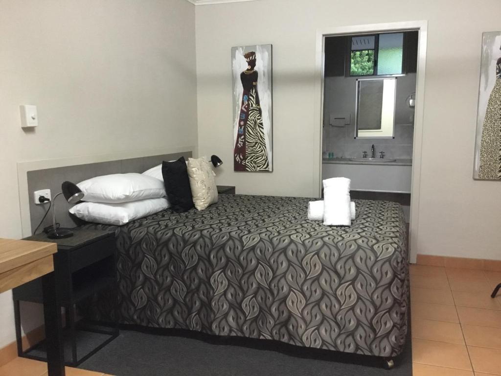 Postel nebo postele na pokoji v ubytování Golden Palms Motor Inn