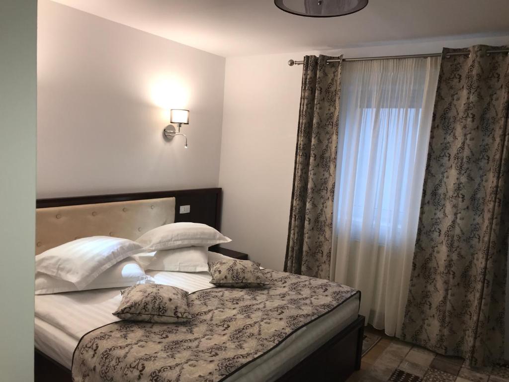 a bedroom with a bed with pillows and a window at Casa Pino in Braşov