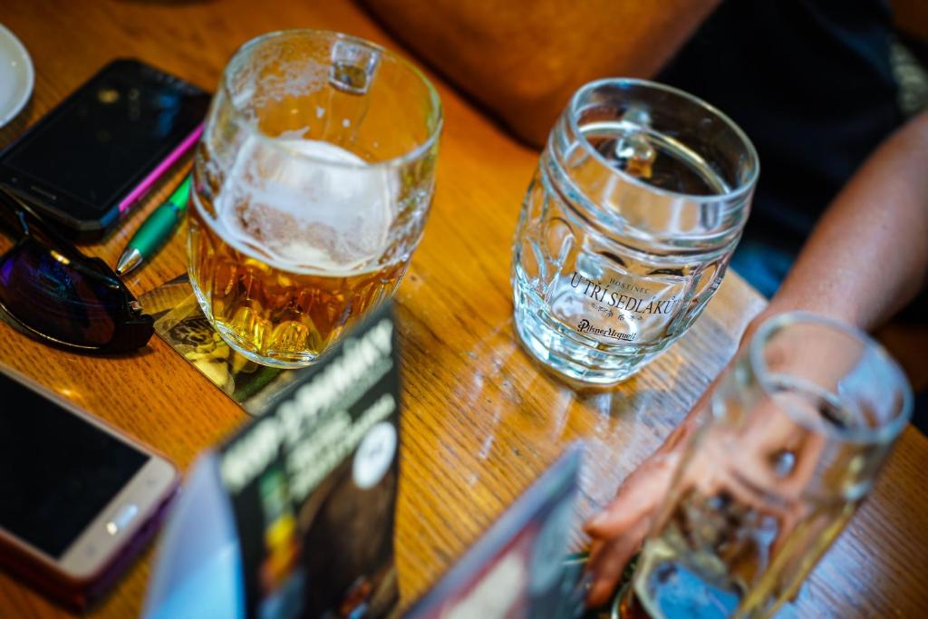two glasses of water sitting on a wooden table at Pension U Tří sedláků in České Budějovice