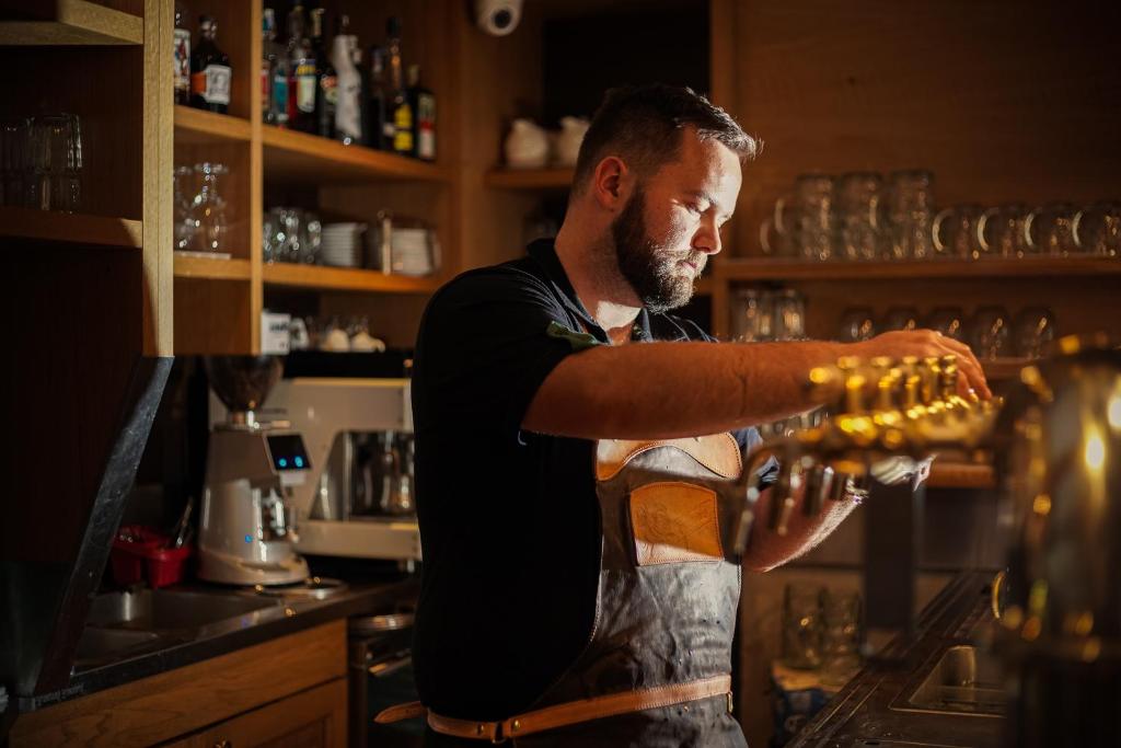 a man is making a glass in a bar at Pension U Tří sedláků in České Budějovice