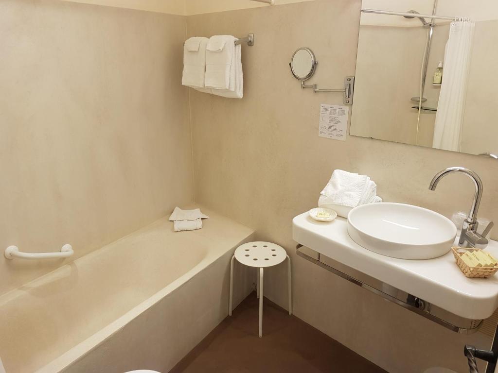 a bathroom with a sink and a bath tub at Hôtel de Charme Brise Marine in Saint-Jean-Cap-Ferrat