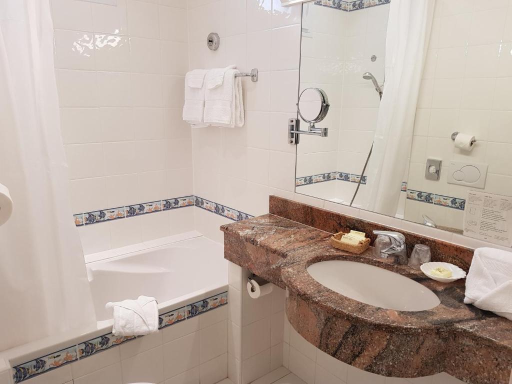 a bathroom with a sink and a tub at Hôtel de Charme Brise Marine in Saint-Jean-Cap-Ferrat