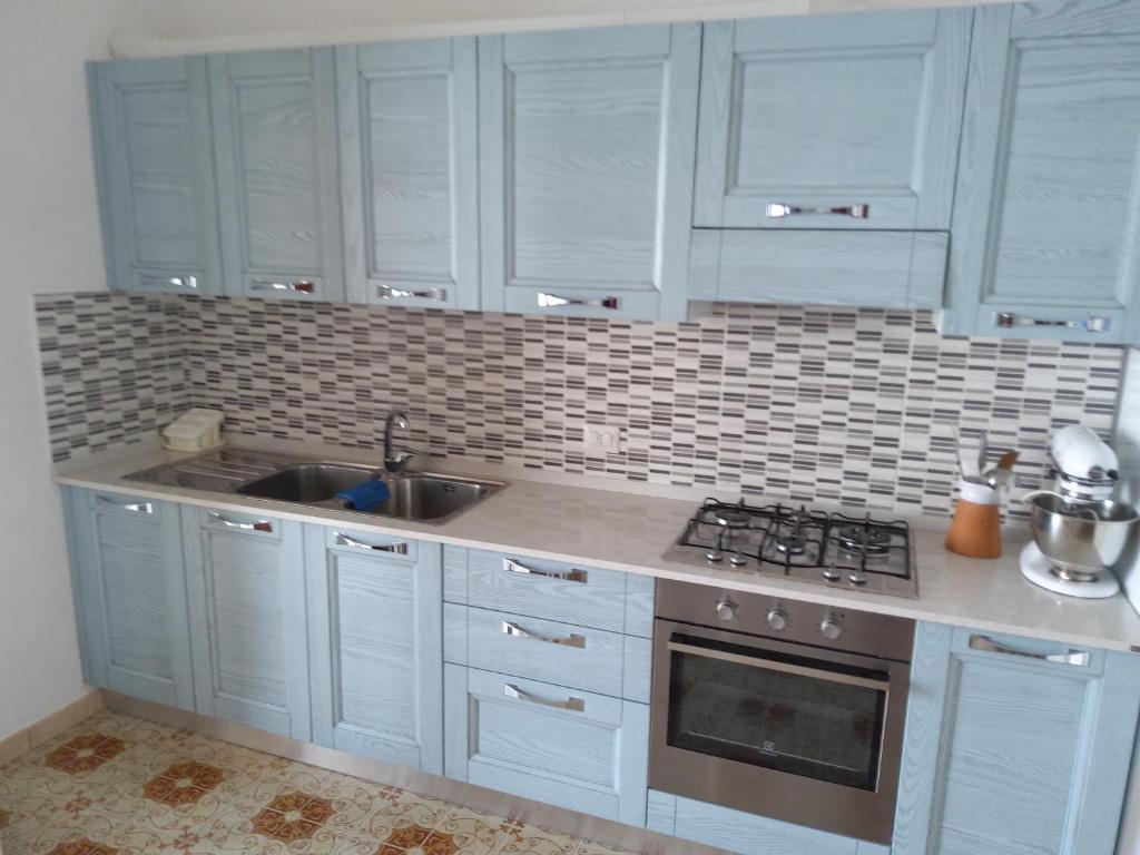 a kitchen with white cabinets and a sink at GIARDINO SUL MARE in Amalfi