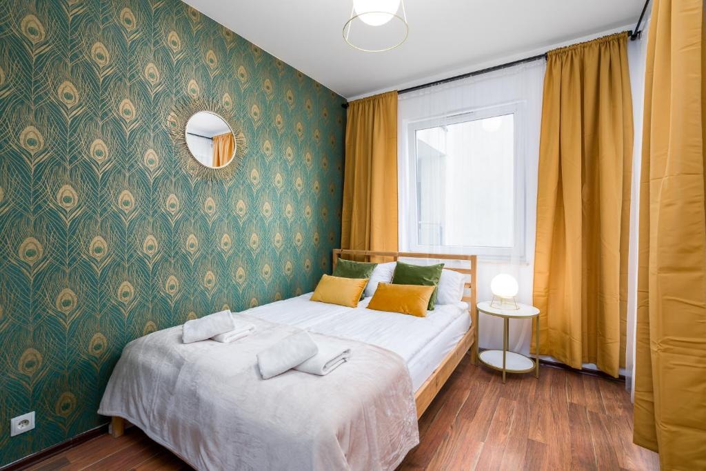 a bedroom with a bed with a green wall at Sleepway Apartments -Garbary 95-101D in Poznań