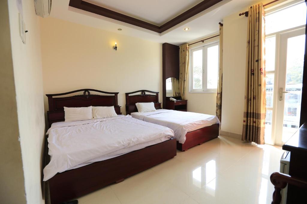 - une chambre avec 2 lits et une fenêtre dans l'établissement The Art - Tuan Viet Hotel, à Hô-Chi-Minh-Ville