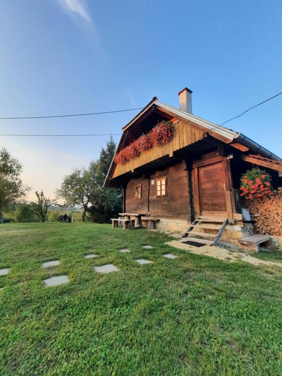 a log cabin in a field next to a field at Rustic home Mia in Duga Resa