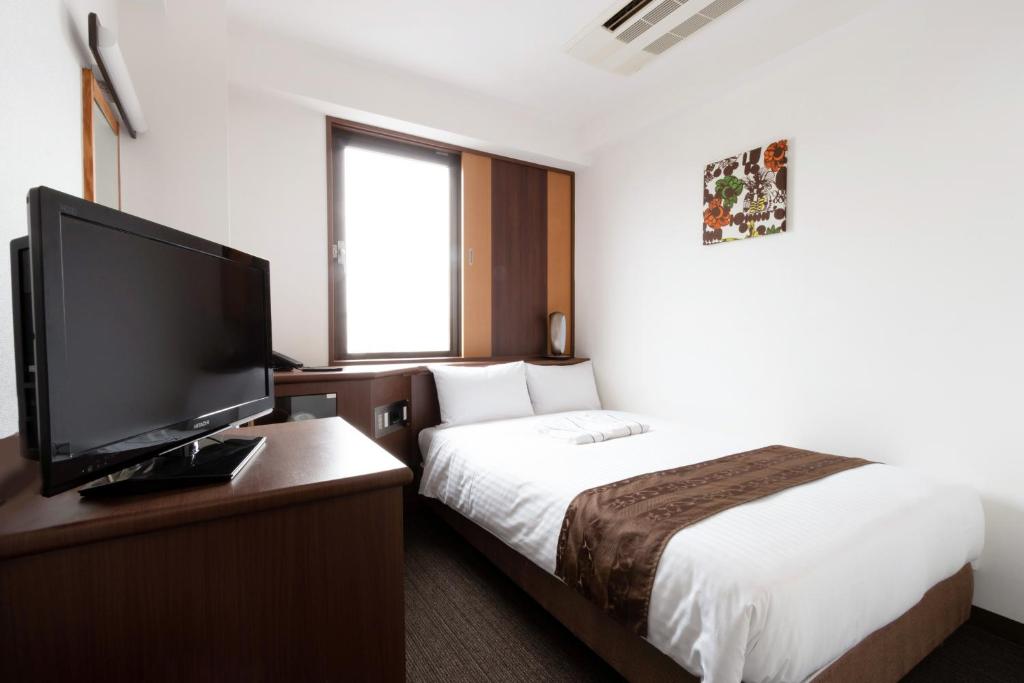 Postel nebo postele na pokoji v ubytování Toyo Hotel